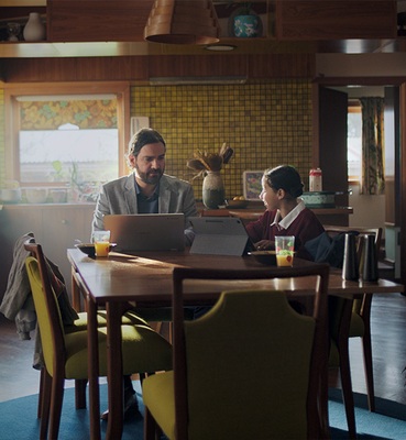 A Parent and Child sitting at a table looking at Chromebooks